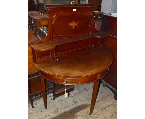 An Edwardian inlaid mahogany demi-lune side table, with raised back and oval panel inlaid with a Grecian urn above two drawer