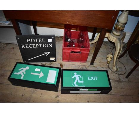 A vintage slate sign 'Hotel Reception', two illuminated fire exit signs and a quantity of advertising milk bottles.