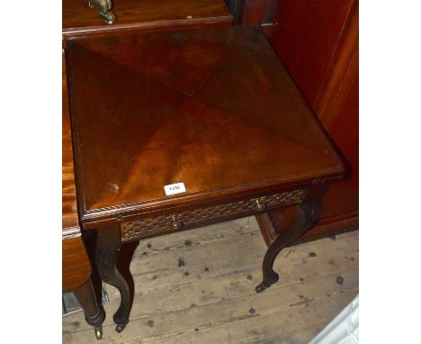 An Edwardian mahogany envelope card table, with single drawer and carved cabriole supports terminating on castors.