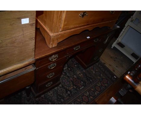 An early 20th century kneehole desk with an arrangement of nine drawers on plinth base, width 137cm, depth 55cm, height 81cm.