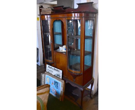 An Edwardian inlaid mahogany bowfronted display cabinet with central bevelled mirror plate flanked by two curved glazed doors