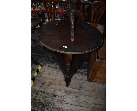 An 18th century pine cricket table with brass edge, diameter 77cm, height 67cm.Condition Report: Splits and a patch repair to