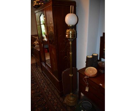 A Victorian brass adjustable oil lamp with associated milk glass shade and chimney, on column terminating on a circular plint