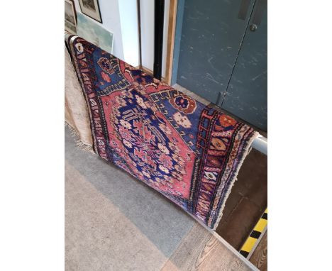 A vintage Eastern wall carpet; blue ground, approx 187 by 97 cm. 