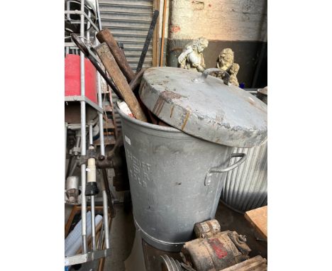 A galvanised dust bin containing various tools. 