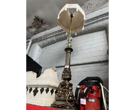 A metal standard decorative lamp with tasseled shade. 