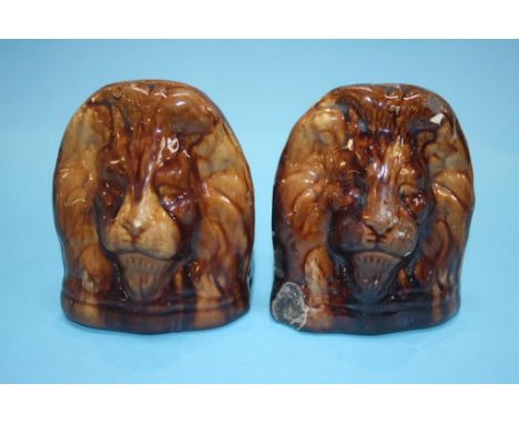 A pair of 19th century treacle glazed pottery Sash window rests, formed as Lion heads (2)