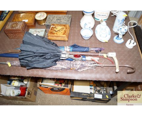 A vintage horn handled riding whip with silver collar; and various parasols and umbrellas 