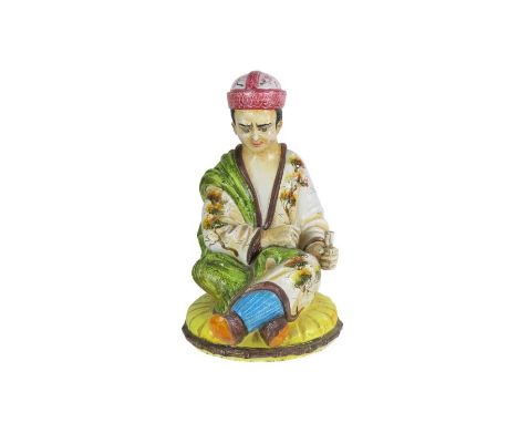 A large glazed pottery figure of a seated Chinese man holding a scroll in his left hand, 64cm high  