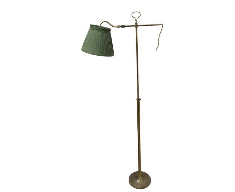 An early 20th century brass adjustable floor lamp with shaped carrying loop and adjustable “S” shaped arm supporting the ligh