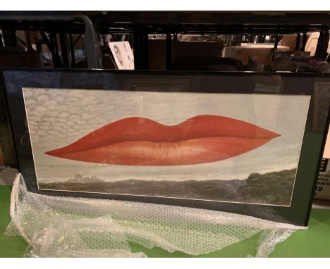 A FRAMED PRINT OF A LANDSCAPE WITH A PAIR OF RED PAINTED LIPS AS A CLOUDSIZE 110CM X 20CM 