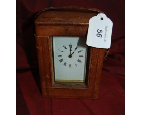 Early 20thC brass carriage clock in a leather case probably French.