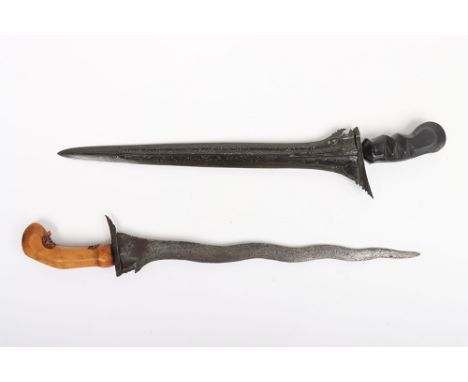 Fine Bali Kris, straight blackened blade with silver-coloured pamor  33cms, ebonised hilt carved with folded design; and anot