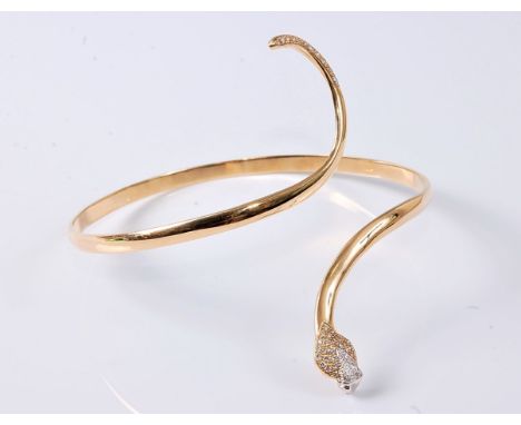 A 14ct diamond set upper arm snake bangle, the cobra style head pave set with small round diamonds and red hardstone eyes, wi