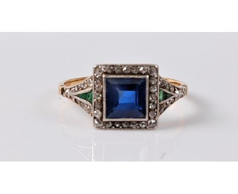 An early 20th century sapphire, emerald and diamond ring, the step cut sapphire approx. 5.5mm square, surrounded by small rou