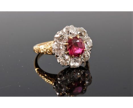 A ruby and diamond ring, the central round ruby, approx. 6.9mm diameter x 4mm deep, surrounded by eight old European cut diam