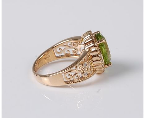 A peridot and diamond ring, the oval peridot approx. 10.9 x 8.7mm, in a four claw mount, surrounded by a single row of small 