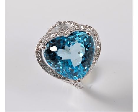 A topaz and diamond ring, the horizontally set heart shaped topaz in a three claw mount, surrounded by a single row of small 