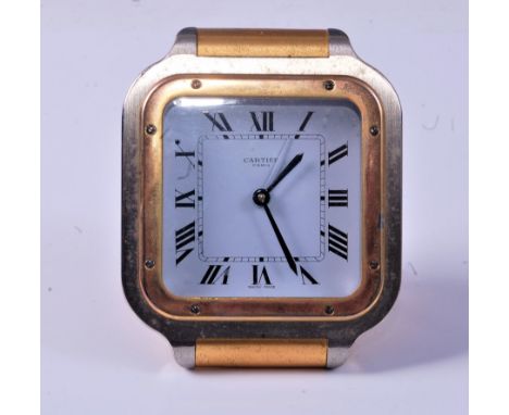 A Cartier steel and gilt brass cased travel alarm clock, having signed white dial and quartz movement, the backplate numbered