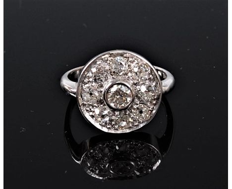 An 18ct diamond target ring, the central round brilliant cut diamond in a rubover mount, set to a round plaque of eight old c