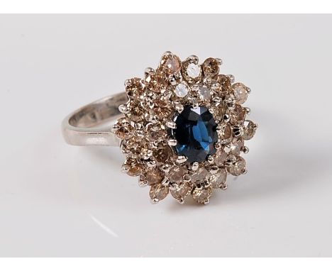 An 18ct sapphire and diamond cluster ring, the oval sapphire, approx. 6.5 x 5.5mm, surrounded by two rows of round brilliant 