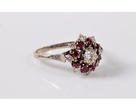 A ruby and diamond cluster ring, the central round brilliant cut diamond surrounded by a graduated tier of alternating rubies