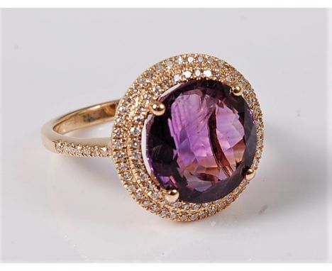 An amethyst and diamond ring, the round amethyst approx. 11.8mm diameter, in a four claw mount and surrounded by two tiers of