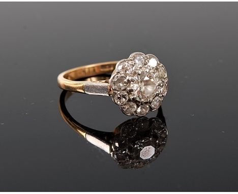 A diamond cluster ring, the central old round brilliant cut diamond, estimated approx. 0.66cts, surrounded by smaller diamond