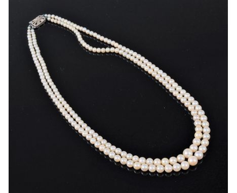A two strand pearl necklace, the graduated pearls, ranging between approx. 2.8 -7mm, with rectangular pierced white metal cla