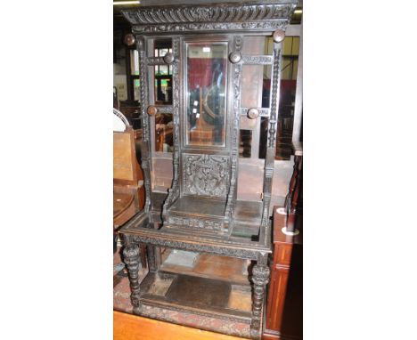 A Gothic revival oak carved hallstand, out curved cornice bevel edge mirror flanked by spiral fluted pilasters and turned hat