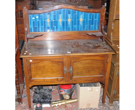 An Edwardian mahogany tile back washstand, two door cupboard to base, tapering square supports, ceramic casters, boxwood stri