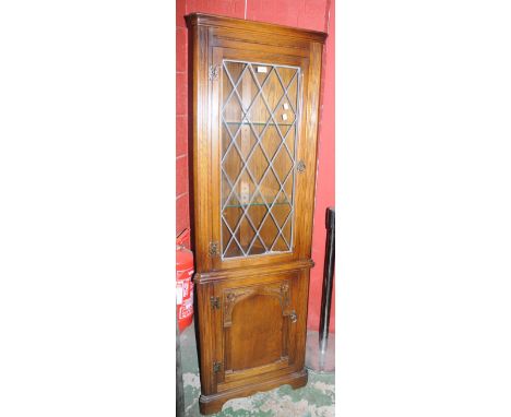 An Andrena light oak floor standing corner cabinet. leaded glazed door to top, arched panel door to bse. 182cm high x 59cm wi