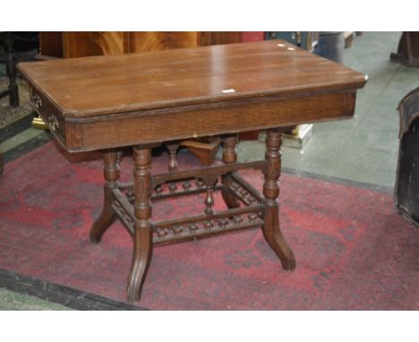 An oak card table, fold over top enclosing green baize playing surface, turned supports, spindle galleried stretchers.