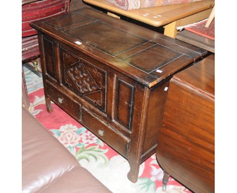A 1940's mule chest, hinged top, carved panel front, two short drawers, shaped legs. 72cm high x 98cm wide x 47.5cm deep.