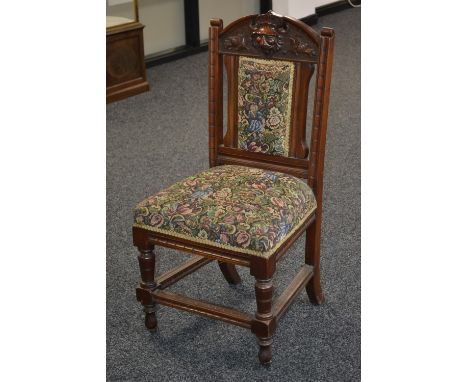 A late Victorian mahogany chair, lion mask cartouche to arched top rail, padded back, stuffed overseat, turned forelegs, cera