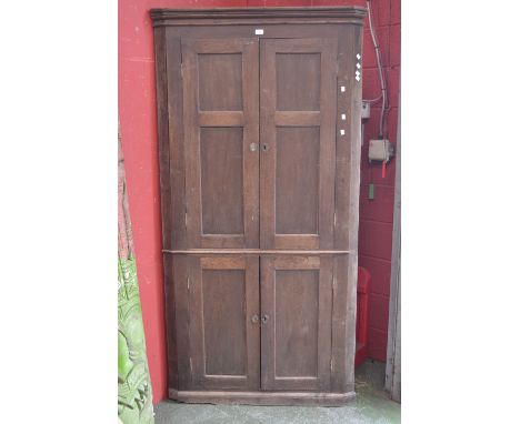 A George III floor standing oak corner cupboard of large proportions, stepped cornice, two panel door cupboard to top, simila