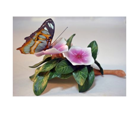 Bisque Porcelain Decorated by Artist Ian D. Lee featuring a Butterfly on a Rose Periwinkle Floral Sculpture. Issued: 1985. Ma