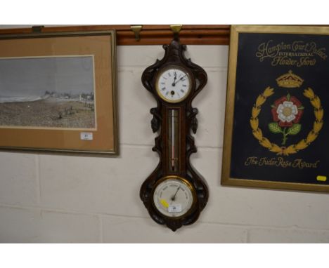 A late 19th Century combined barometer, clock and thermometer, in carved walnut case 