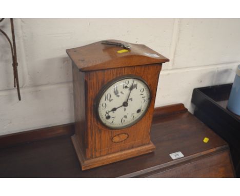 An Edwardian oak and inlaid two hole mantel clock 