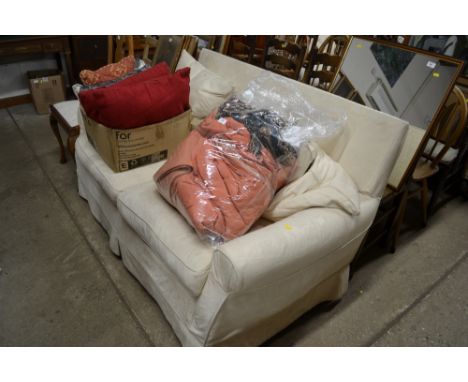 A large loose covered white upholstered two seater sofa 