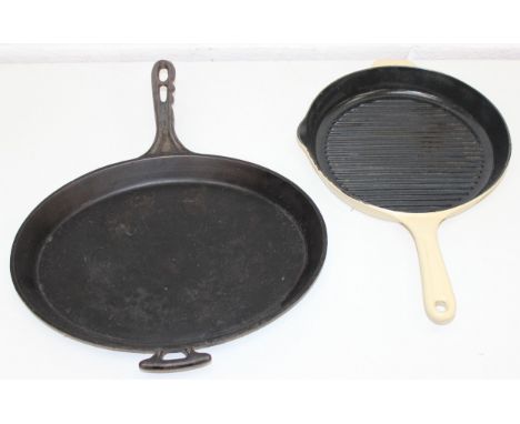 2 cast iron griddle or skillet pans, 1 in cream enamel by RGA, the other by Holcroft, largest 39cm x 30cm (excl handles)
