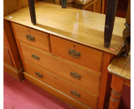 An early 20th century light oak chest of two short over two long drawers