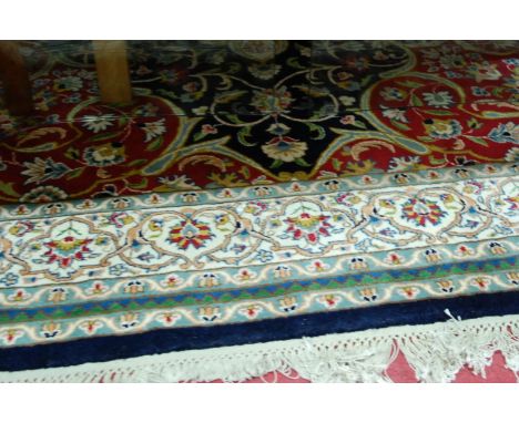 A Persian Tabriz style woollen carpet, having a centre medallion issuing scroll flowers and foliage within trailing tramline 