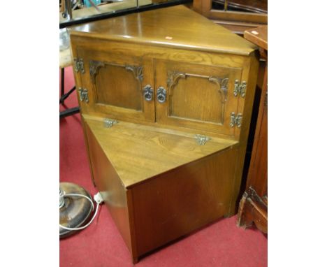 A reproduction mahogany freestanding corner cabinet; together with an Old Charm oak low corner settle; and a made-up oak hang