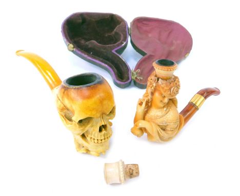 A meerschaum pipe, modelled as a hand holding skull, with simulated amber cheroot, 15cm long, together with a further meersch
