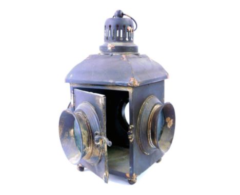 An early 20thC ebonised tin lantern, with four circular glass faces, on bun feet, 36cm high. 