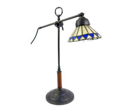 A Tiffany style table lamp, the adjustable arm with a cream and blue diamond Tiffany style shade, on a stepped circular foot 