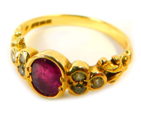 An 18ct gold ruby and diamond dress ring, the central oval ruby in a rub over setting, with three tiny diamond set shoulders 