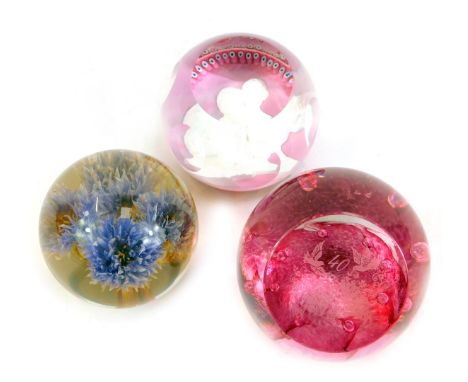 Three glass paperweights, comprising a Caithness Prince and Princess of Wales limited edition number 10/500 pink glass paperw