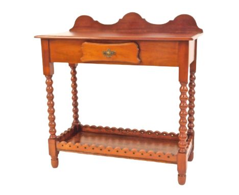 An early 20thC mahogany side table, with a raised shaped back, frieze drawer, raised on bobbin turned legs with under tier, w